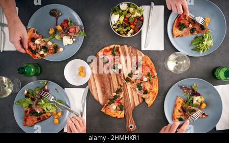 Blick Von Oben Auf Freunde, Die Gemeinsam Pizza Im Restaurant Essen Stockfoto
