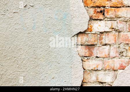 Texturierter Hintergrund einer alten Ziegelmauer, Putz fiel ab, die Gebäudewand wurde draußen zerstört Stockfoto