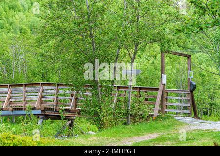 VALLDAL, NORWEGEN - 2020. JUNI 06. Brücke über den Fluss im Wald. Stockfoto