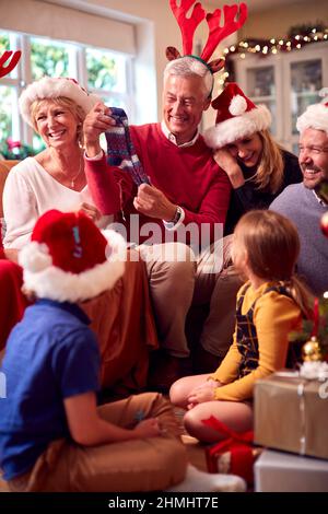 Multi-Generation-Familie Austausch Und Eröffnung Geschenke Rund Um Weihnachtsbaum Zu Hause Stockfoto