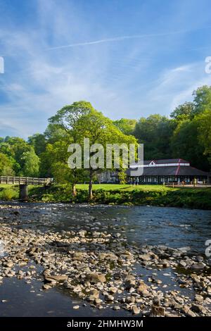 Wunderschöne Landschaft im Sommer (Café Cavendish Pavilion & Besucher am Flussufer) - sonniges Bolton Abbey Estate, Yorkshire Dales, England, Großbritannien. Stockfoto