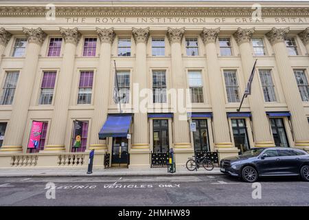 10. Februar 2022. Die Colonnaded Royal Institution in der Albemarle Street, Mayfair, London mit Parkplatz für Elektrofahrzeuge vor dem Hotel Stockfoto