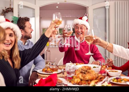 Multi Generation Family In Santa Hats Beim Gemeinsamen Weihnachtsessen Stockfoto