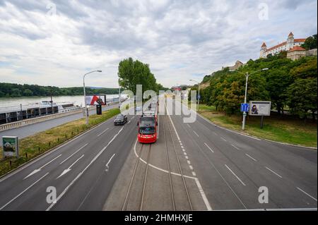 BRATISLAVA, SLOWAKEI - 9. JULI 2019: Eine Straßenbahn fährt auf der Straße vor der Burg Bratislava vorbei Stockfoto