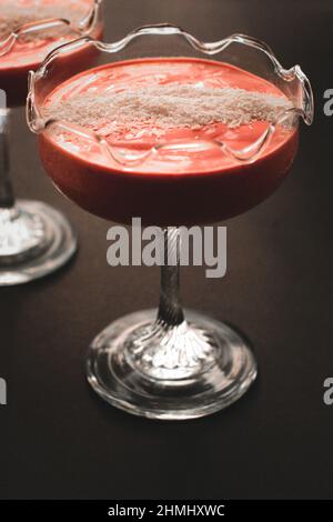 Himbeere - Kokosnussjoghurt in einer Glasschüssel auf dunklem Grund Stockfoto
