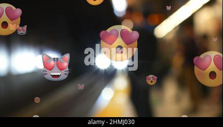 Bild von mehreren Emoji-Symbolen mit Herzaugen im Hintergrund über dem nicht fokussieren Zug Stockfoto