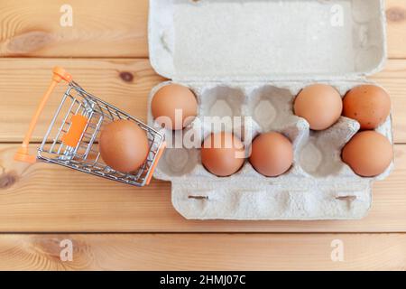 Ein paar Hühnereier im Warenkorb neben Pappbeutel, ein Hühnereier als wertvolles nahrhaftes Produkt, ein Tablett zum Tragen und Aufbewahren von Fragi Stockfoto