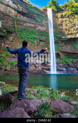 Junger Mann am Wasserfall fallende Ströme von der Bergspitze mit Reflexion aus verschiedenen Perspektiven Bild auf phe phe Fall meghalaya indien aufgenommen. Es ist Stockfoto