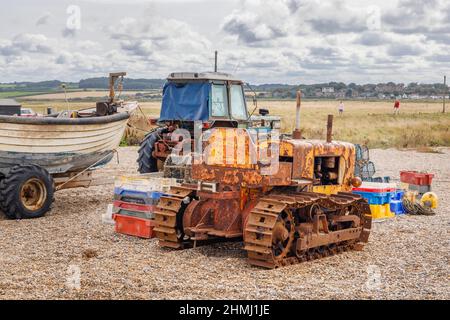 Ein rostiger Vintage-Planierraupen und ein Traktor an einem Kiesstrand, Cley-Next-the-Sea, einem Küstendorf, Nordküste Norfolk, East Anglia, England Stockfoto
