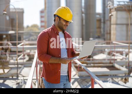 Junger Wirtschaftsingenieur mit Laptop im Werk Stockfoto