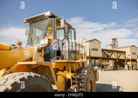 Manueller Arbeiter, der den Laster im Werk fährt Stockfoto