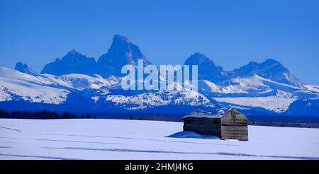 Teton Mountains Grand Tetons im Winter mit altem Hüttengebäude im Feld Stockfoto