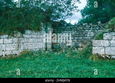 Bremenium - ein altes römisches Fort (Castrum) in Rochester, Northumberland, England. Die Festung war eine der Verteidigungsstrukturen entlang der Dere Street, einer römischen Straße, die von York nach Corbridge und weiter nach Melrose führt. Westwand mit einem Tor. Archivscan von einem Dia. Oktober 1974. Stockfoto