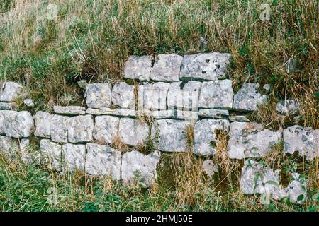 Bremenium - ein altes römisches Fort (Castrum) in Rochester, Northumberland, England. Die Festung war eine der Verteidigungsstrukturen entlang der Dere Street, einer römischen Straße, die von York nach Corbridge und weiter nach Melrose führt. Westwand. Archivscan von einem Dia. Oktober 1974. Stockfoto