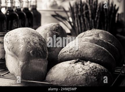 Brot kühlen auf einem Regal in einem Delikatessenladen, umgeben von Flaschen und Spargel Stockfoto