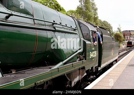 Swanage, Dorset, England - 2021. Juni: Zugfahrer blickt aus dem Taxi einer Dampfmaschine neben dem Bahnsteig am Bahnhof von Swanage Stockfoto
