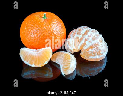 Mandarinen auf reflektierendem schwarzem Studiohintergrund Stockfoto