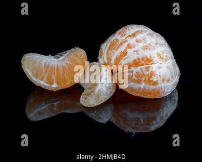 Mandarinen auf reflektierendem schwarzem Studiohintergrund Stockfoto
