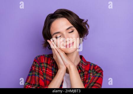 Foto von schläfrig tausendjährigen Brünette Dame Schlaf tragen rotes Hemd isoliert auf lila Hintergrund Stockfoto