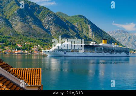 Große touristische Schiff schwamm in einer Bucht der Adria segeln vorbei an kleinen Stadt. Der Hintergrund der Berge. Stockfoto