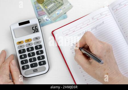 Der Rentner berechnet die Versorgungskosten. Ältere Frauenhände zählen Finanzen auf einem Rechner Stockfoto