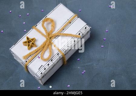 Musikalische Geschenk für Weihnachten, Silvester oder zum Geburtstag. Auf einem Bogen mit einem Stern in der Nähe gebunden. Stockfoto