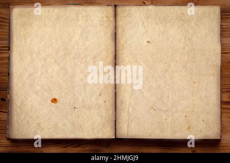 Ein altes, ausgeklapptes, zerfetztes und vergilbtes Buch mit leeren Seiten. Stockfoto