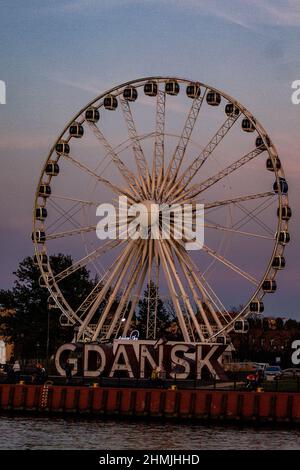 Riesenrad am Abend mit großen Buchstaben, die Gdańsk sagen Stockfoto