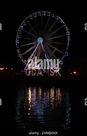 Riesenrad in der Nacht mit großen Buchstaben sagen Gdańsk Stockfoto