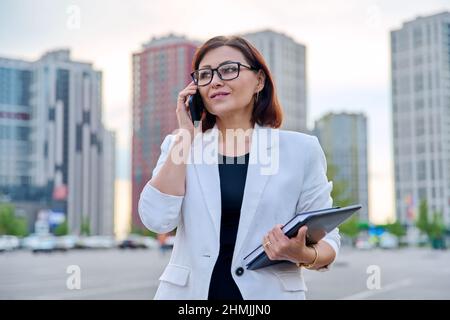 Porträt einer erfolgreichen reifen Geschäftsfrau mit Smartphone im Freien Stockfoto