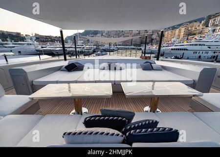 Das vordere Deck der riesigen Yacht im Hafen von Monaco bei Sonnenuntergang, der Ort für die Landung des Hubschraubers, viele Motorboote sind im Hintergrund, das Chrom Stockfoto