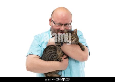 Ein kahler Mann hält eine Katze in den Armen und lächelt. Stockfoto