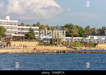 Pathos. Zypern. November 2019. Touristen tauen in der Nähe der Küste. Der Damm der Stadt Paphos in Zypern vom Meer aus. Spätherbst ist immer noch die Stockfoto