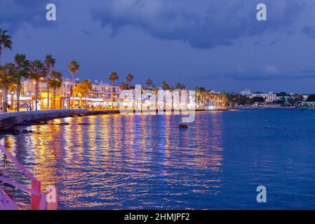 Pathos. Zypern. November 2019. Abendpromenade in der Stadt Paphos. Das Ufer des Resorts Stadt unter dem Licht der Laternen. Die Menschen gehen entlang der Th Stockfoto