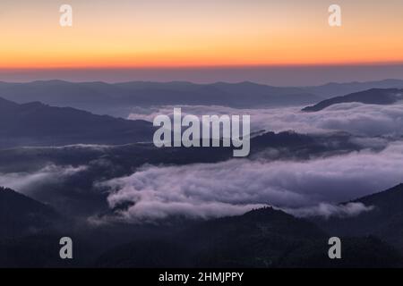 Sonnenaufgang am nebligen Morgen. Landschaft mit hohen Bergen. Touristischer Ort. Natürliche Landschaft. Standort Karpaten, Ukraine, Europa. Hintergrundbilder Stockfoto