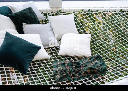 Komfortable Hängematte mit Karaster und Kissen im Wohnzimmer Stockfoto
