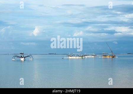 Fischerboote schwimmen auf dem Meer. Holzboot, das in offenen Gewässern segelt. Segelbootlandschaft. Tropische Landschaft. Bali, Indonesien. Sommerurlaub Stockfoto