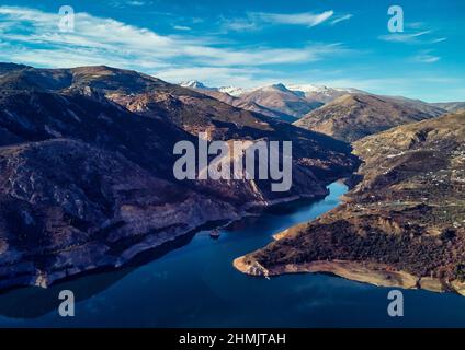 Luftdrohne Sichtbild felsige schneebedeckte Berge der Sierra Nevada Embalse de Canales Reservoir in Guejar Sierra, Provinz Granada, Andalus Stockfoto