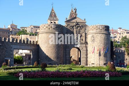 Das Neue Bisagra Tor Puerta de Bisagra Nueva, berühmte Stadttore von Toledo, Blick von außerhalb der Stadt mit blühenden Blumenbeet. Castilla-La Mancha, Spa Stockfoto