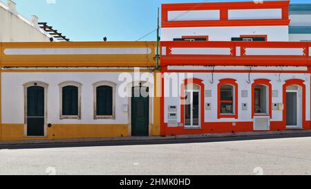 Weiß und gelb-rot-blau bemalte neoklassische Stadthäuser - Rua Porta Nova Street. Tavira-Portugal-095 Stockfoto