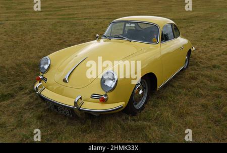 Klassischer gelber Porsche 356s isoliert auf Gras geparkt. Stockfoto