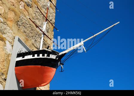 Der Bug eines Schiffes ragt aus einer Steinmauer am Woods Hole Oceanographic Institute auf Cape Cod Stockfoto