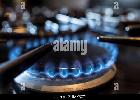 Nahaufnahme von brennenden Gasringen, die auf dem Kochfeld eines Hausgaskochers in einer britischen Küche leuchten. Stockfoto