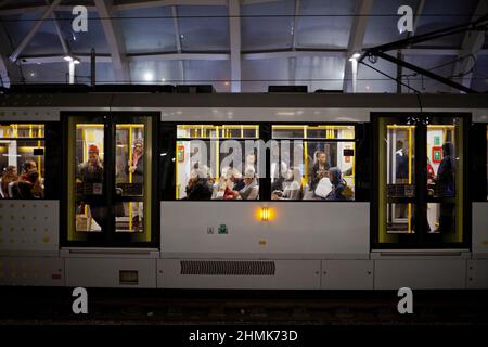 Passagiere, die mit der Straßenbahn Manchester Metrolink reisen Stockfoto