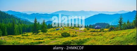 Panorama des malerischen Polonyna Smotrych Bergtals, umgeben von tiefen Fichtenwäldern und Silhouetten der Karpaten, Ukraine Stockfoto