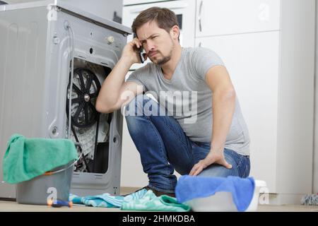 Verstörter Mann im Zimmer, der mit Wasser überflutet war Stockfoto