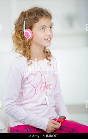 Ein Schulmädchen, das Kopfhörer hört Stockfoto