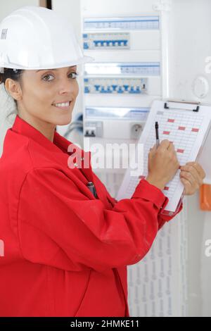 Elektrikerin, die das Sparmessgerät steuert Stockfoto