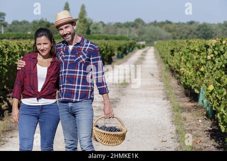 Glückliche Winzerfamilie, die im Weinberg spazieren geht Stockfoto