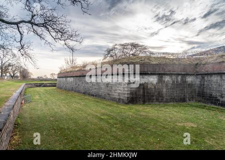 Luftaufnahme des historischen Backsteins Fort Jay auf Governors Island, der den Hudson River in New York bewacht, mit Blick auf die Wolkenkratzer des Finanzdistr Stockfoto